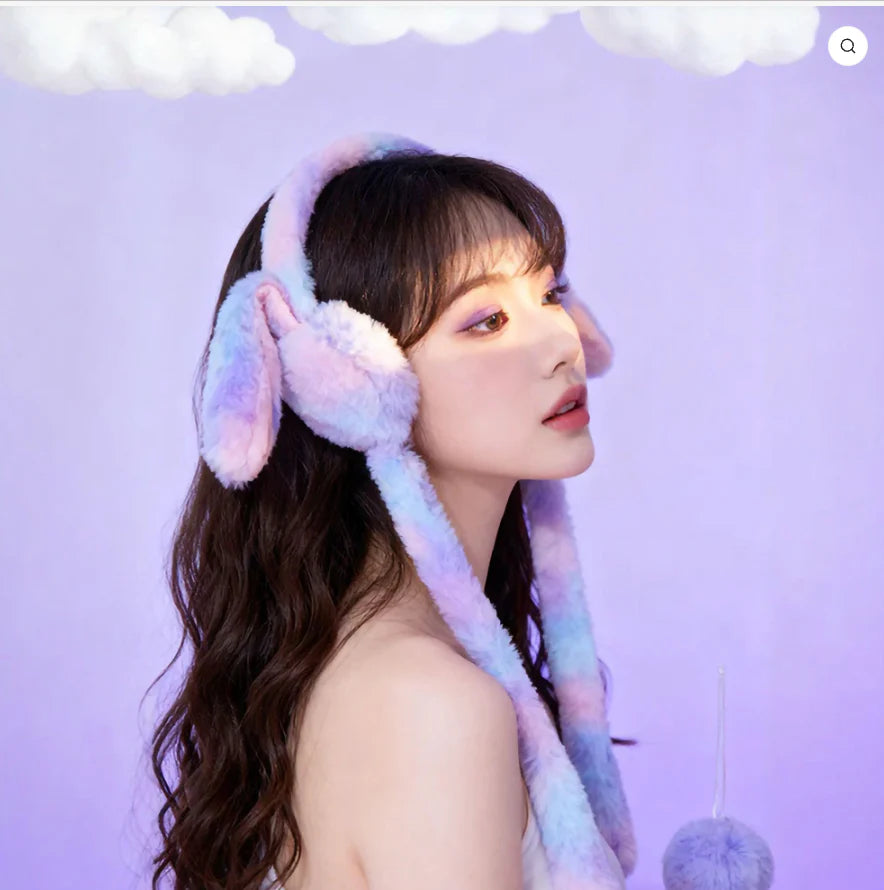 Person wearing colorful bunny-shaped ear muffs against a light purple background