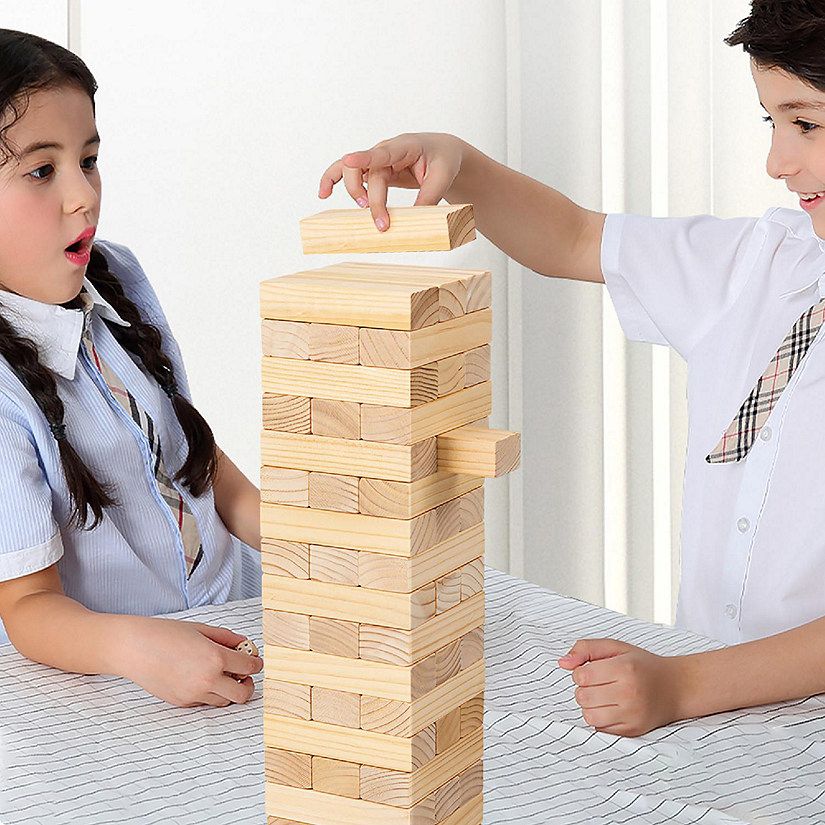 Two children playing with a tower of wooden blocks.