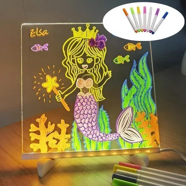 Mermaid drawing on a light-up board with markers on a wooden surface