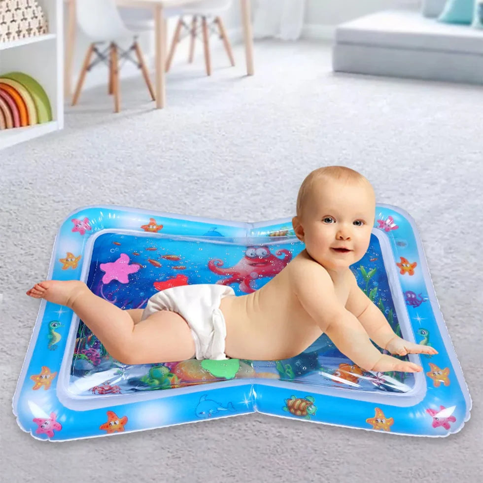 Baby playing on an inflatable water mat with sea creature designs in a room.