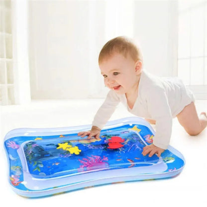 Baby playing on an inflatable water mat with colorful designs.