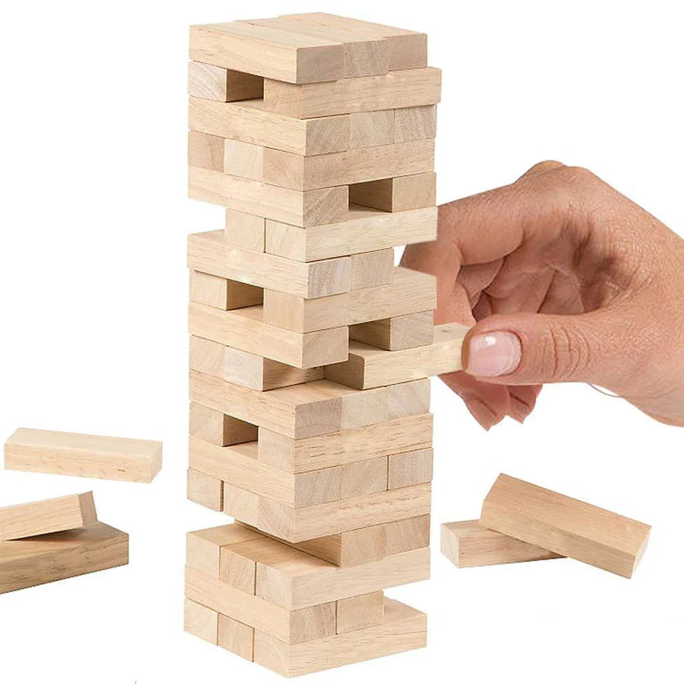 Wooden block tower game with a hand adding a block, on a white background