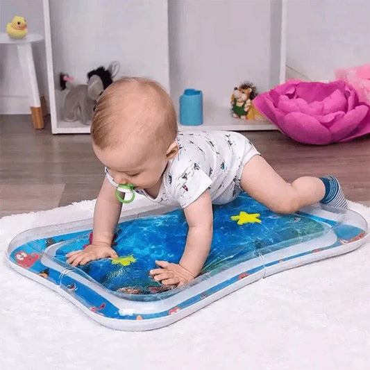 Baby playing on an inflatable water mat with toys in a room setting.